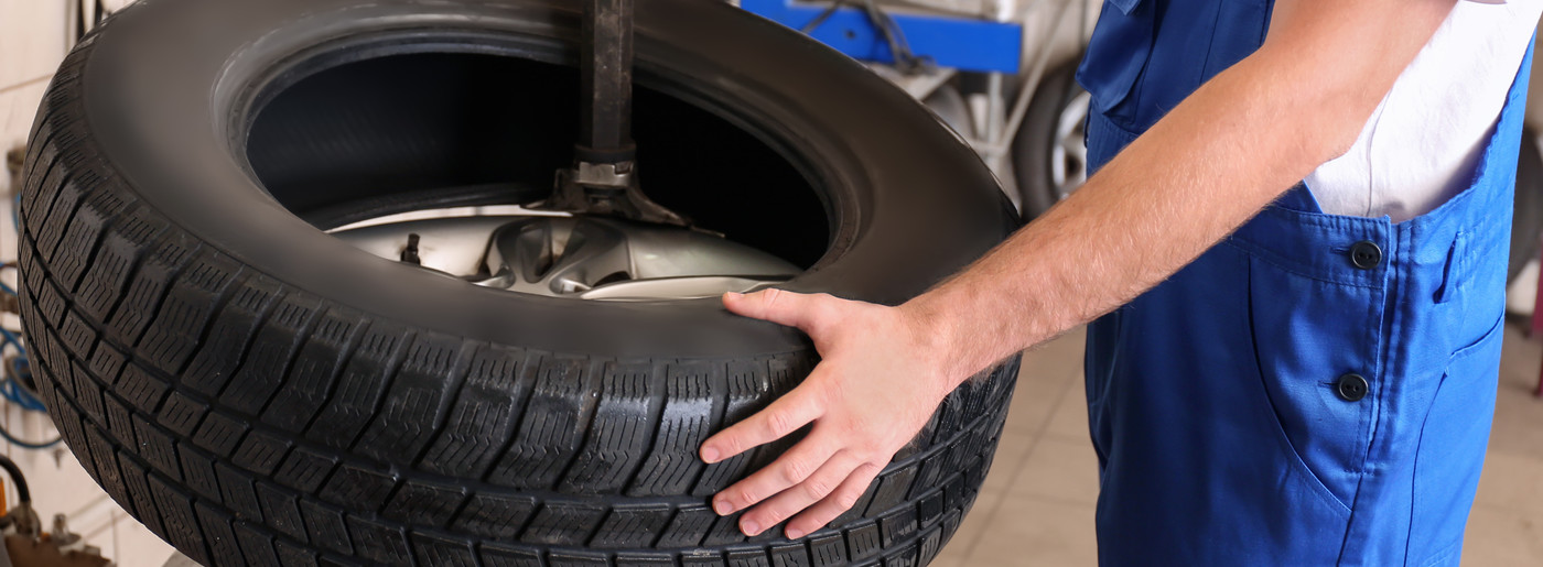 Tyre mechanic holding a brand new tyre - Tyres Edmonton